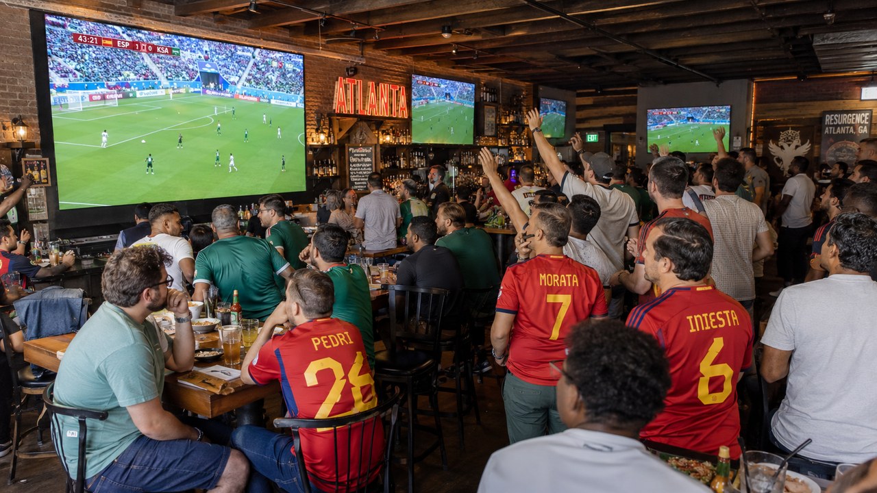 Soccer fans in Spain jerseys watch Spain vs Saudi Arabia on big screens at an Atlanta sports bar during the World Cup