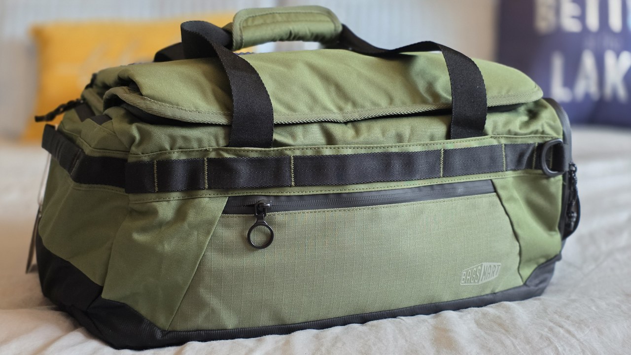 BagSmart Paz 43L Duffle Backpack in olive green resting on a bed