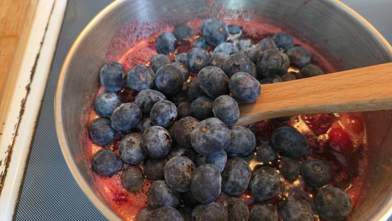 adding blueberries to cranberry sauce