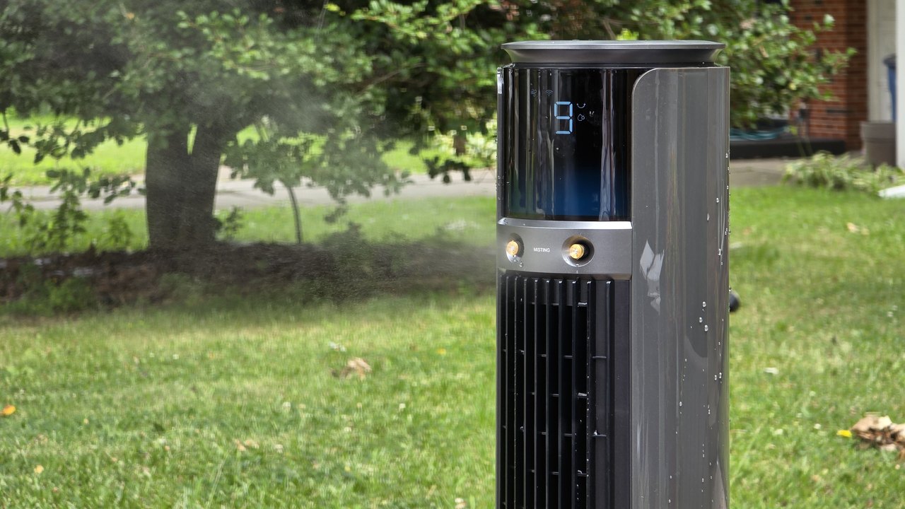 Dreo TurboCool 711AS outdoor misting fan running on a lawn with mist blowing across the yard