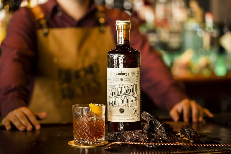 Ancho Reyes Old Fashioned with a bottle of Ancho Reyes Original