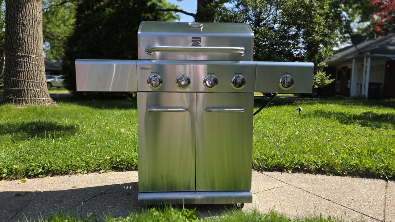 Kenmore 4-Burner Gas Grill with Side Searing Burner in stainless steel, lid closed, on a backyard patio