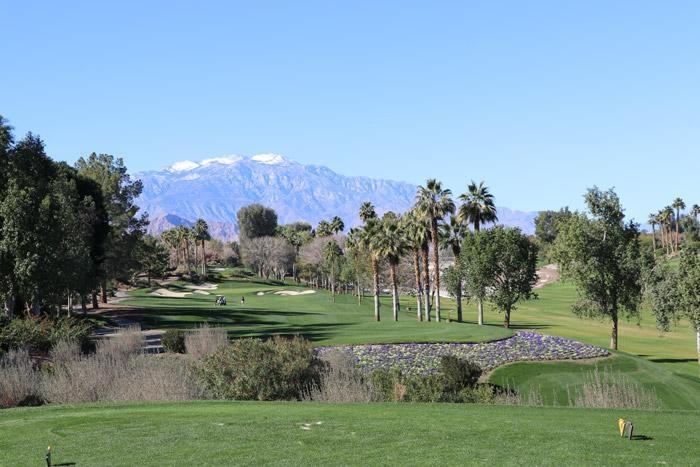 indian well golf course snow capped mountains and palm trees
