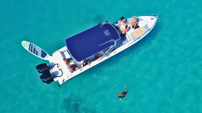 Aerial view of a private charter boat off St Maarten with a snorkeler in the water and a paddleboard at the stern