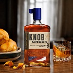 Knob Creek BBQ Old Fashioned cocktail with an orange peel next to the Independence Edition bottle