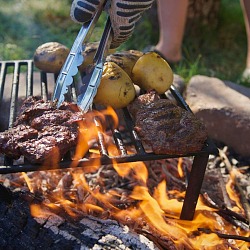 Modern Escapes for Men Who Love a Little Adventure at Home grilling steaks and potatoes