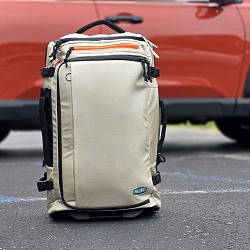 BagSmart Blast 43L Roller Backpack standing upright in a parking lot in front of an SUV
